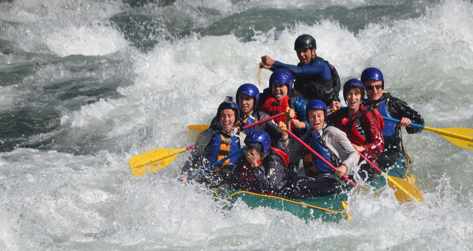 Gummibåt fylt med mennesker som rafter i stri elv.