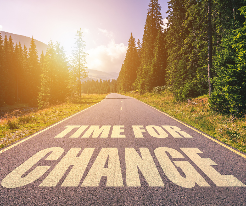 Asfaltert vei i skogen med ordene time for change malt på veien.
